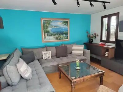 a living room with a couch and a table at Private Garden Home next to the beach and market in Athens