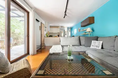 a living room with a couch and a table at Private Garden Home next to the beach and market in Athens