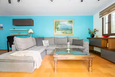 a living room with a couch and a table at Private Garden Home next to the beach and market in Athens