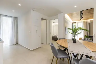 a dining room and living room with a table and chairs at Varkiza Luxury Suites by Raise in Vari
