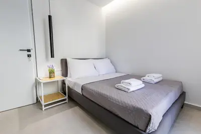 a bedroom with a bed with two towels on it at Varkiza Luxury Suites by Raise in Vari