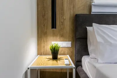a small table with a plant on it next to a bed at Varkiza Luxury Suites by Raise in Vari