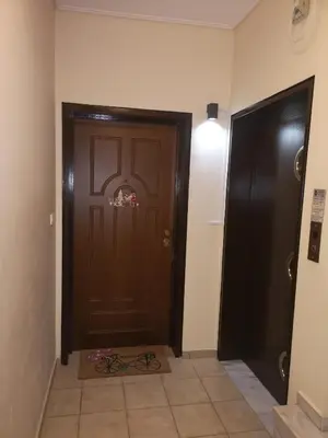 a hallway with a brown door and a tile floor at Athenian Luxury apartment, near metro station Chalandri, Nu 1 in Athens