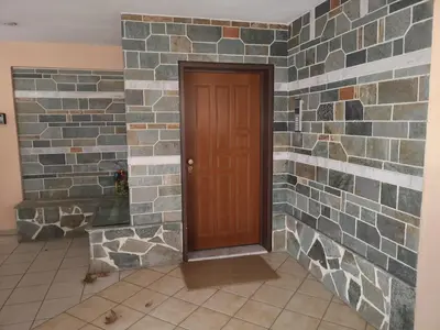 a room with a brick wall with a wooden door at Athenian Luxury apartment, near metro station Chalandri, Nu 1 in Athens
