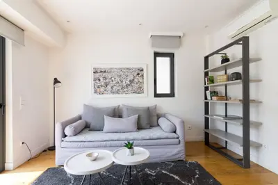 a living room with a couch and two tables at Athens Trikoupi Suite E1 in Athens