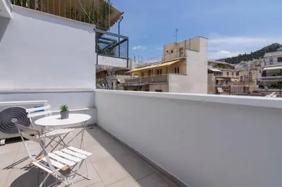 a white balcony with a table and a chair at Athens Trikoupi Suite E1 in Athens