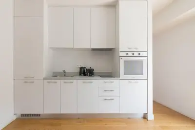 a white kitchen with white cabinets and a microwave at Athens Trikoupi Suite E1 in Athens