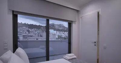 a bedroom with a large window with a view of a city at Athens Trikoupi Suite B3 in Athens