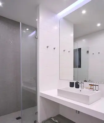 a white bathroom with a sink and a shower at Athens Trikoupi Suite B3 in Athens