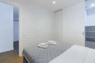a white bedroom with a bed with two towels on it at Athens Trikoupi Suite B3 in Athens