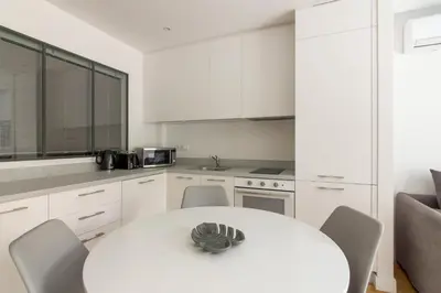 a white kitchen with a white table and chairs at Athens Trikoupi Suite B3 in Athens