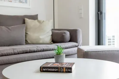 a book on a table in a living room with a couch at Athens Trikoupi Suite B3 in Athens