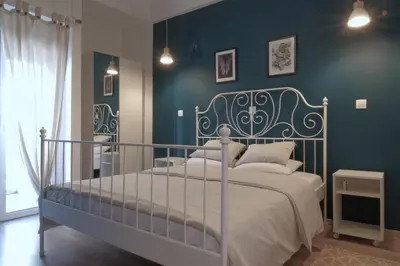 a bedroom with a bed and a blue wall at You & Me Cozy Apartments BY ZAIN in Athens