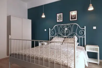 a bedroom with a bed with a blue wall at You & Me Cozy Apartments BY ZAIN in Athens