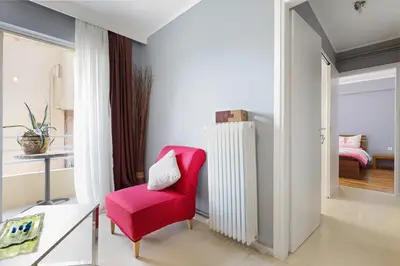 a living room with a red chair and a radiator at Thanasis Family Apartment in Athens