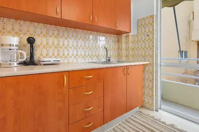 a kitchen with wooden cabinets and a sink at Thanasis Family Apartment in Athens