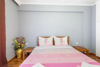 a bedroom with a pink and white bed with pink pillows at Thanasis Family Apartment in Athens