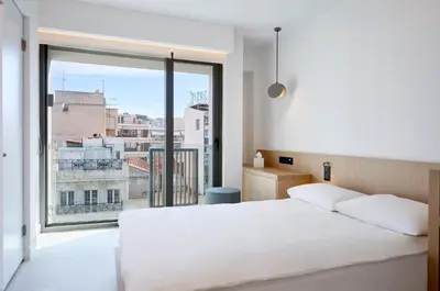 a bedroom with a white bed and a large window at Twinn Downtown Piraeus, Santikos Collection in Piraeus