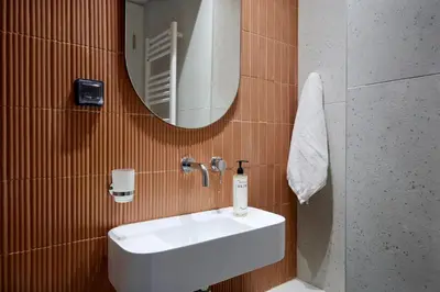 a bathroom with a white sink and a mirror at Twinn Downtown Piraeus, Santikos Collection in Piraeus