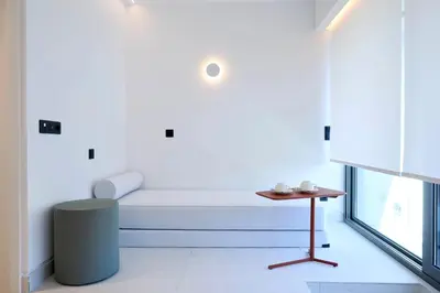 a white bed in a room with a table at Twinn Downtown Piraeus, Santikos Collection in Piraeus