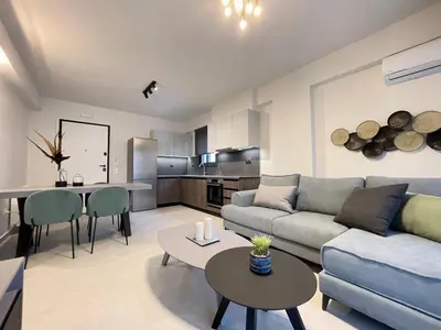 a living room with a couch and a table at Athenean Gem near Athens Metro Mall in Athens