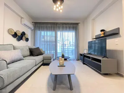 a living room with a couch and a tv at Athenean Gem near Athens Metro Mall in Athens