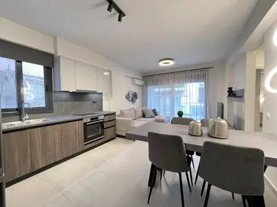a kitchen and living room with a table and chairs at Athenean Gem near Athens Metro Mall in Athens