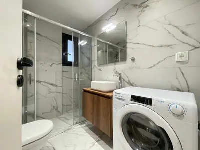 a washing machine in a bathroom with a shower at Athenean Gem near Athens Metro Mall in Athens