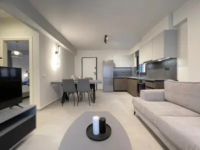 a living room with a couch and a table and a kitchen at Athenean Gem near Athens Metro Mall in Athens