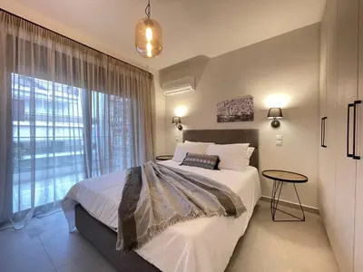 a bedroom with a bed and a large window at Athenean Gem near Athens Metro Mall in Athens