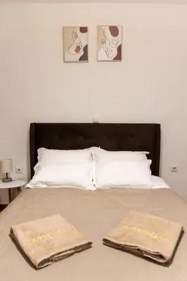 two towels sitting on top of a bed at Sympatico Central Apartment in Athens in Athens