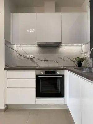 a kitchen with white cabinets and a black oven at Athenean Modern Escape near Marina Flisvos in Athens