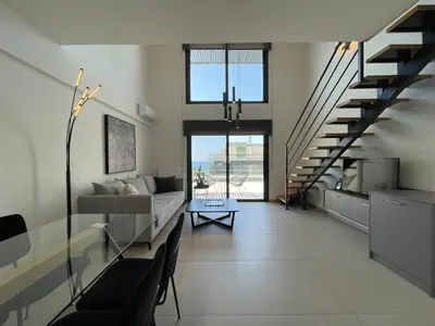 a living room with a couch and a staircase at Athenean Modern Escape near Marina Flisvos in Athens