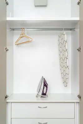 a white dresser with a shelf and a tie at Athenean Modern Escape near Marina Flisvos in Athens