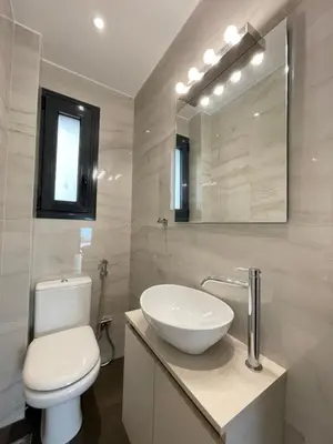 a bathroom with a toilet and a sink and a mirror at Athenean Modern Escape near Marina Flisvos in Athens