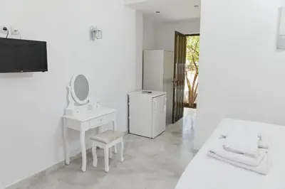 a white bathroom with a sink and a mirror at Golden Star Praxitelous in Agia Marina Aegina