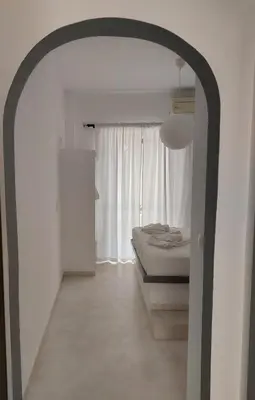 a white room with a bed and a window at Golden Star Praxitelous in Agia Marina Aegina