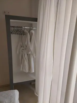 a bedroom with a closet with white curtains at Golden Star Praxitelous in Agia Marina Aegina