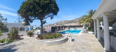 a house with a swimming pool and a tree at Villa Mare Nostrum Sounio in Sounio