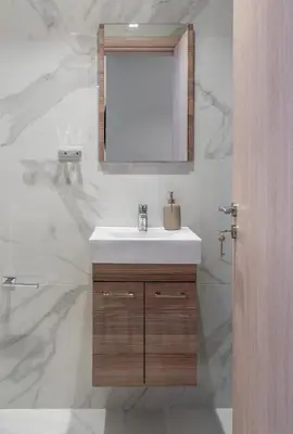 a bathroom with a sink and a mirror at Glyfada Diamond Residence - 3 Master Bedrooms in Athens