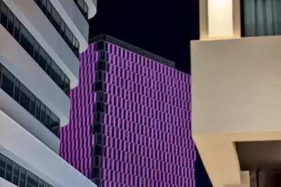 a tall building with purple lights on it at Athenarum Portus Life & Style Hotel in Piraeus