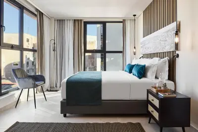 a hotel room with a bed and a chair and window at Athenarum Portus Life & Style Hotel in Piraeus