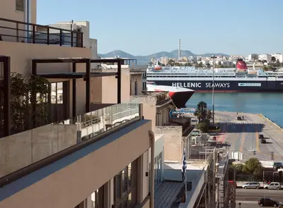 a cruise ship is docked next to a building at Athenarum Portus Life & Style Hotel in Piraeus