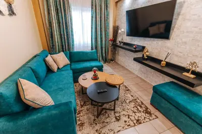 a living room with a blue couch and a tv at Peaceful moments in Athens