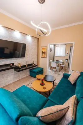 a living room with a blue couch and a table at Peaceful moments in Athens