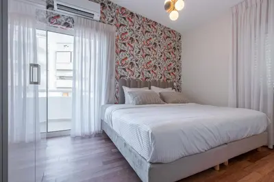 a bedroom with a large bed with a red wall at Phaedrus Living: Glyfada Seaview Luxury Penthouse in Athens