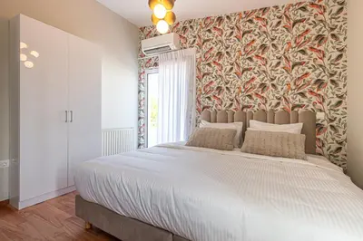a bedroom with a large bed with a floral wallpaper at Phaedrus Living: Glyfada Seaview Luxury Penthouse in Athens