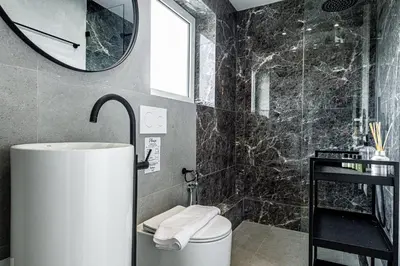 a bathroom with a toilet and a sink and a mirror at Phaedrus Living: Glyfada Seaview Luxury Penthouse in Athens