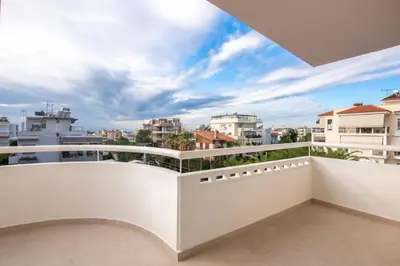a white balcony with a view of the city at Phaedrus Living: Glyfada Seaview Luxury Penthouse in Athens