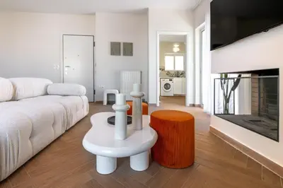 a living room with a white couch and a fireplace at Phaedrus Living: Glyfada Seaview Luxury Penthouse in Athens